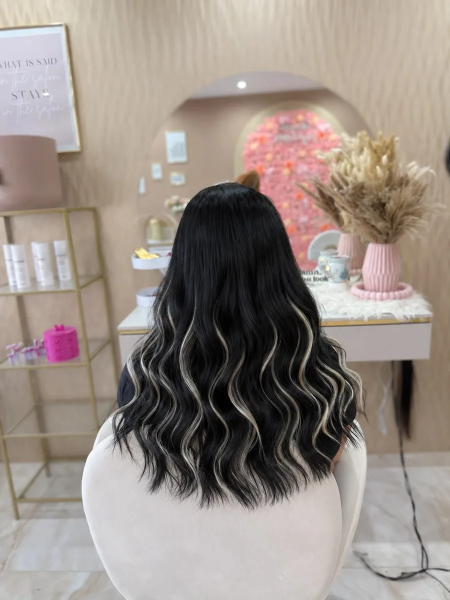 Gewelltes schwarzes Haar mit heller Balayage